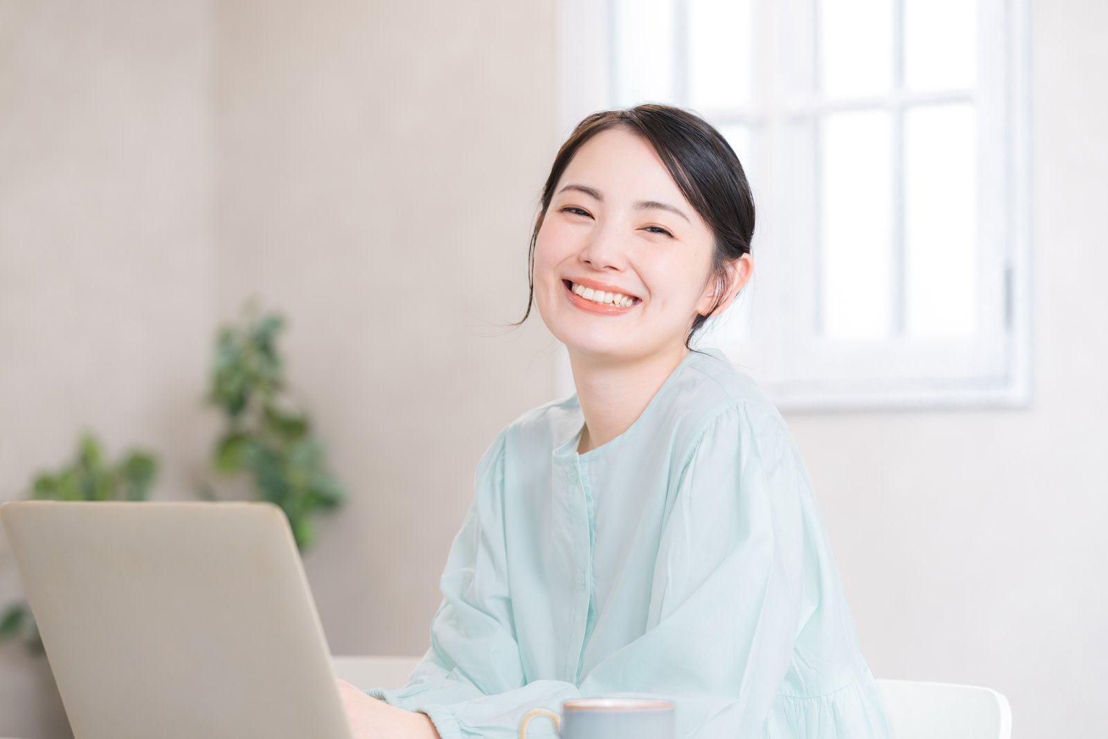 在宅でノートパソコンに向かって働くママ